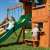 Woodlit Somerset playset with a child going down the slide and another child looking out the window