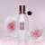 Viktor & Rolf Flowerbomb Dew Eau de Parfum, sticlă albă cu capac negru și etichetă, pe un fundal roz