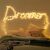 Springos LED fairy lights spelling 'Dreamer' above a bed