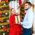 Couple Exchanging Gifts by a Decorated Christmas Tree