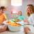 Family enjoying dinner with WiZ smart bulbs providing warm, inviting light