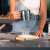 Woman using a flour sifter over a Springos silicone baking mat, with other ingredients