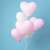 Bunch of pink and white Springos heart balloons on blue background