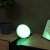 Philips Hue Go smart light bulb, green light, on a table