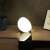 Philips Hue Go smart light bulb, white light, on a table