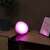 Philips Hue Go smart light bulb, pink light, on a table