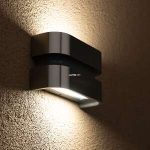 Lutec Maya silberne LED-Außenwandleuchte, die eine strukturierte Wand beleuchtet. - Lutec