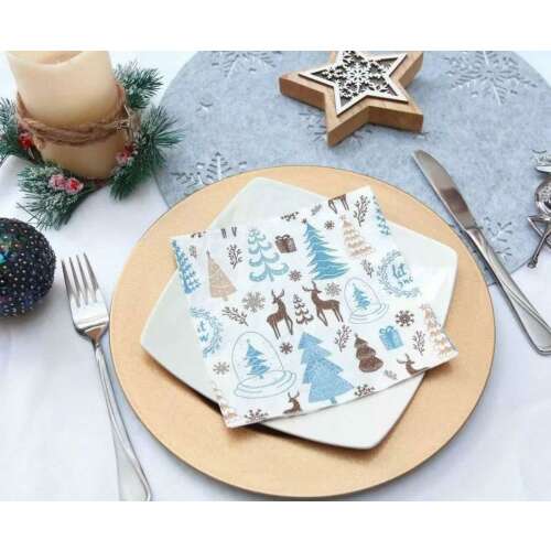 Weihnachts-Servietten mit winterlichem Design mit Bäumen, Hirschen, Schneeflocken und Geschenken auf einer Tischdekoration