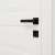 Black door handle set with square rosette installed on a white door