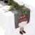 Ruhhy Christmas table runner with gnome decoration on a festive table setting.