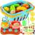 Play kitchen set with a blue basket, a red stove, a yellow teapot, a pink pot, a knife, a cutting board, and toy fruits and vegetables