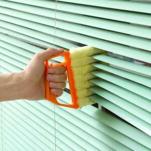 Hand holding Reluxa blind cleaner brush, cleaning green blinds - Cleaning