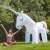 Giant inflatable unicorn sprinkler, woman sitting next to it