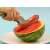 Hand holding a watermelon slicer, cutting a slice of watermelon