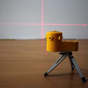 Žltý laserový nivel, ktorý premieta červené laserové čiary na stenu, ideálny pre DIY projekty, domáce vylepšenia a profesionálne použitie - Laserové hladinomery