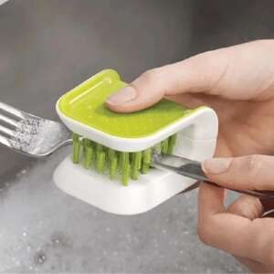 Green and white multi-functional kitchen cleaning brush for cleaning knives and forks, in use - Cleaning brush