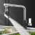 Water saving faucet sprayer in use, kitchen sink, washing vegetables, chrome finish
