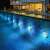 RGB LED pool lights installed in a swimming pool, illuminating the water at night