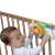 Baby playing with WinFun Baby Driver musical steering wheel toy attached to crib