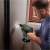Man using Bosch UniversalHammer 18V cordless hammer drill to drill into a wall