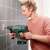 Woman using the Bosch UniversalHammer 18V cordless hammer drill to drill a hole in a tile wall