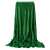 Springos green plush blanket with gold dots, draped over a chair