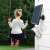 Reolink Go solar powered security camera mounted on a white wooden wall with a girl on a swing in the background