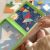 Copil jucându-se cu Tangramul magnetic Tooky Toy, rezolvând puzzle cu racheta