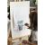 Child painting on wooden artist easel