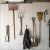 Metal tool hangers organizing various garden tools on a white wall.
