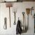 Metal tool hangers organizing various garden tools on a white wall.