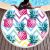 Woman relaxing on round pineapple beach towel by pool
