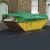 Green waterproof tarp covering a skip filled with household items