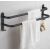 Matte black aluminum towel rack with towels in bathroom setting.