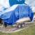 Blue waterproof tarp with metal grommets, 4.0m x 5.0m, 80g/m2, covering a boat on a trailer