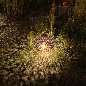 Illuminated Navaris solar lantern casting decorative shadows in garden - Nonbrand Solar lantern