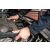 Közelkép egy férfi kezéről NEO Garage munkadzseki ujjaiban, autó motoralkatrészeket kezel, bemutatva a mozgásszabadságot