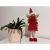 Christmas fairy decoration with red dress and golden wings next to a plant