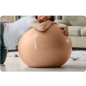 Schwangere Frau, die einen Nukido beige Fitnessball für Schwangerschaftsübungen verwendet - Fitness-Bälle