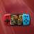Rote und blaue Handheld-Spielkonsole mit 620 eingebauten Spielen, mit einem Schießspiel auf dem Bildschirm