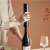 Person using the electric wine opener set to open a bottle of wine