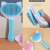 Collage of the blue and white cat shaped pet brush with handle, showing the hair removal button and the anti-skid button