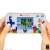 Hands holding Tetris Gamer V 200 handheld game console, white, blue, red, yellow, green, purple, black