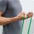 Man using NEO SPORT green resistance band for workout
