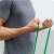 Man demonstrating exercise using green resistance band