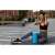 Woman using blue foam roller for stretching exercises outdoors