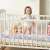 Toddler standing in crib with Ricokids braided bumper