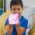 Child holding Luna the Calming Kitty night light, showing the light glowing pink