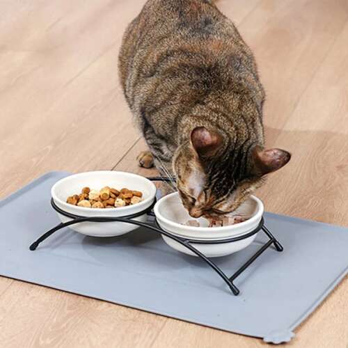 Pisică mâncând din boluri pe un covoraș antiderapant pentru hrana animalelor de companie