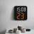 HG8015 digital alarm clock mounted on a wall in a kitchen setting